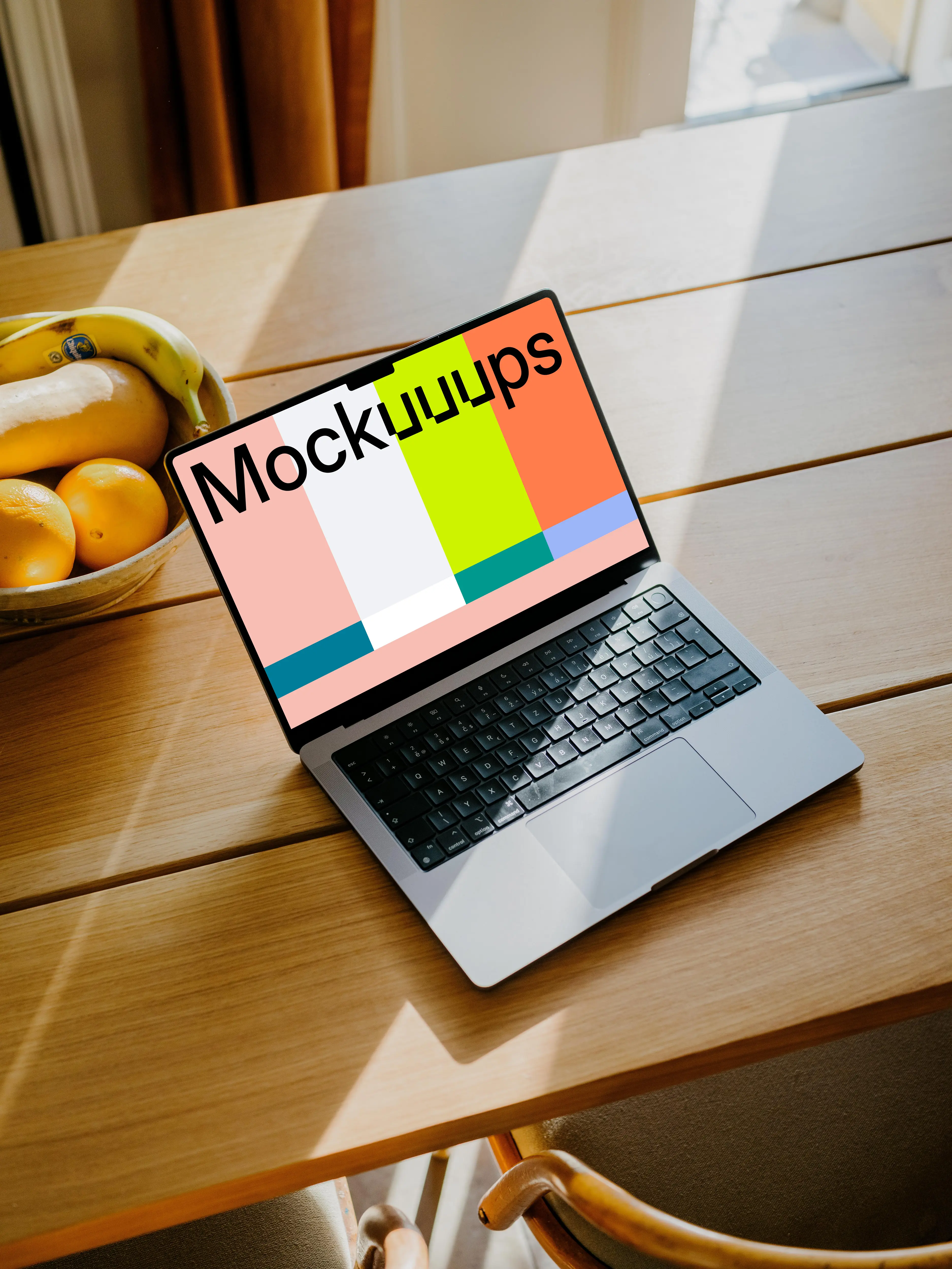 MacBook Pro mockup on a table in front of a basket of fruits