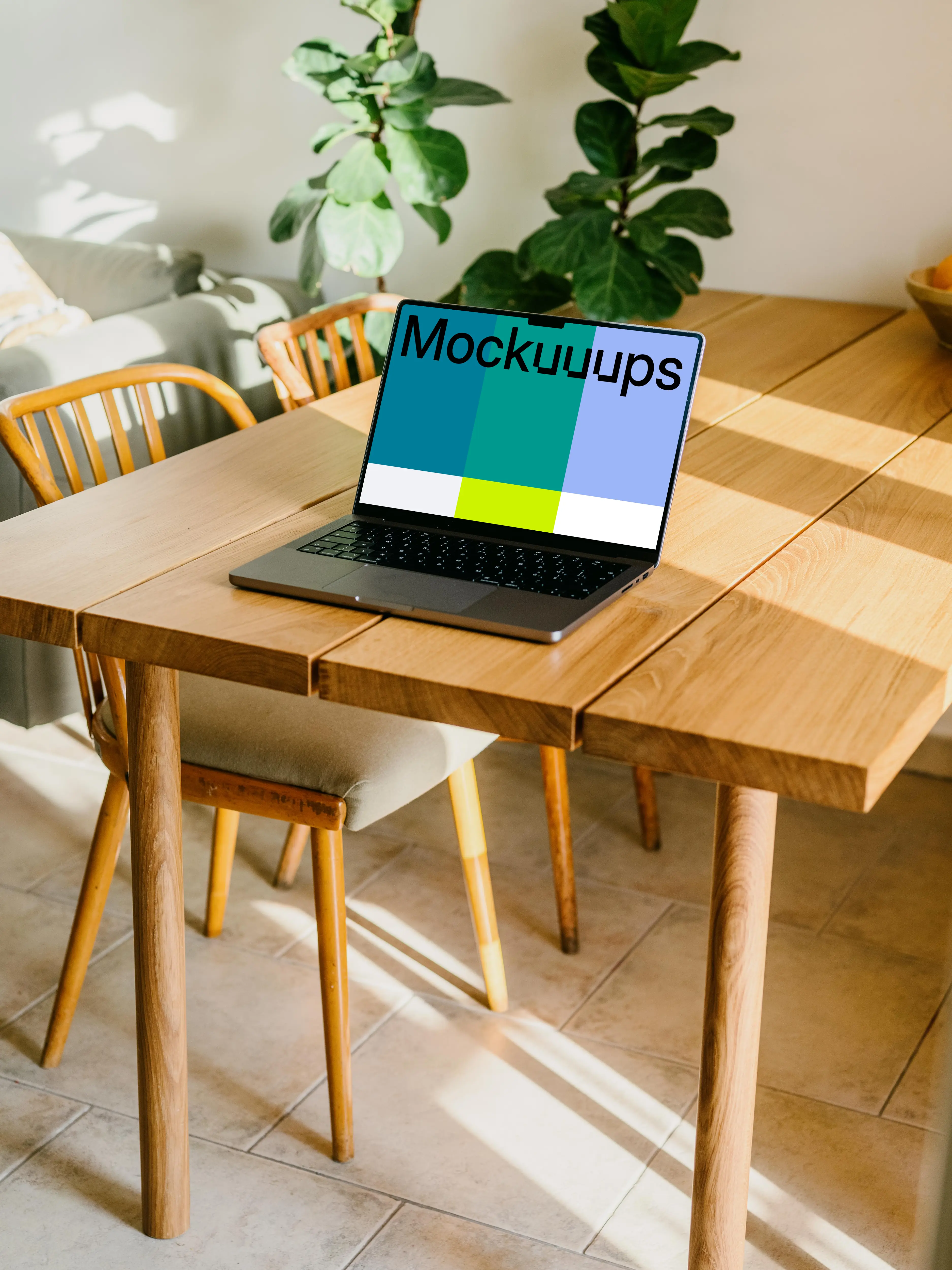 Free MacBook Pro mockup on a table with a plant in the background