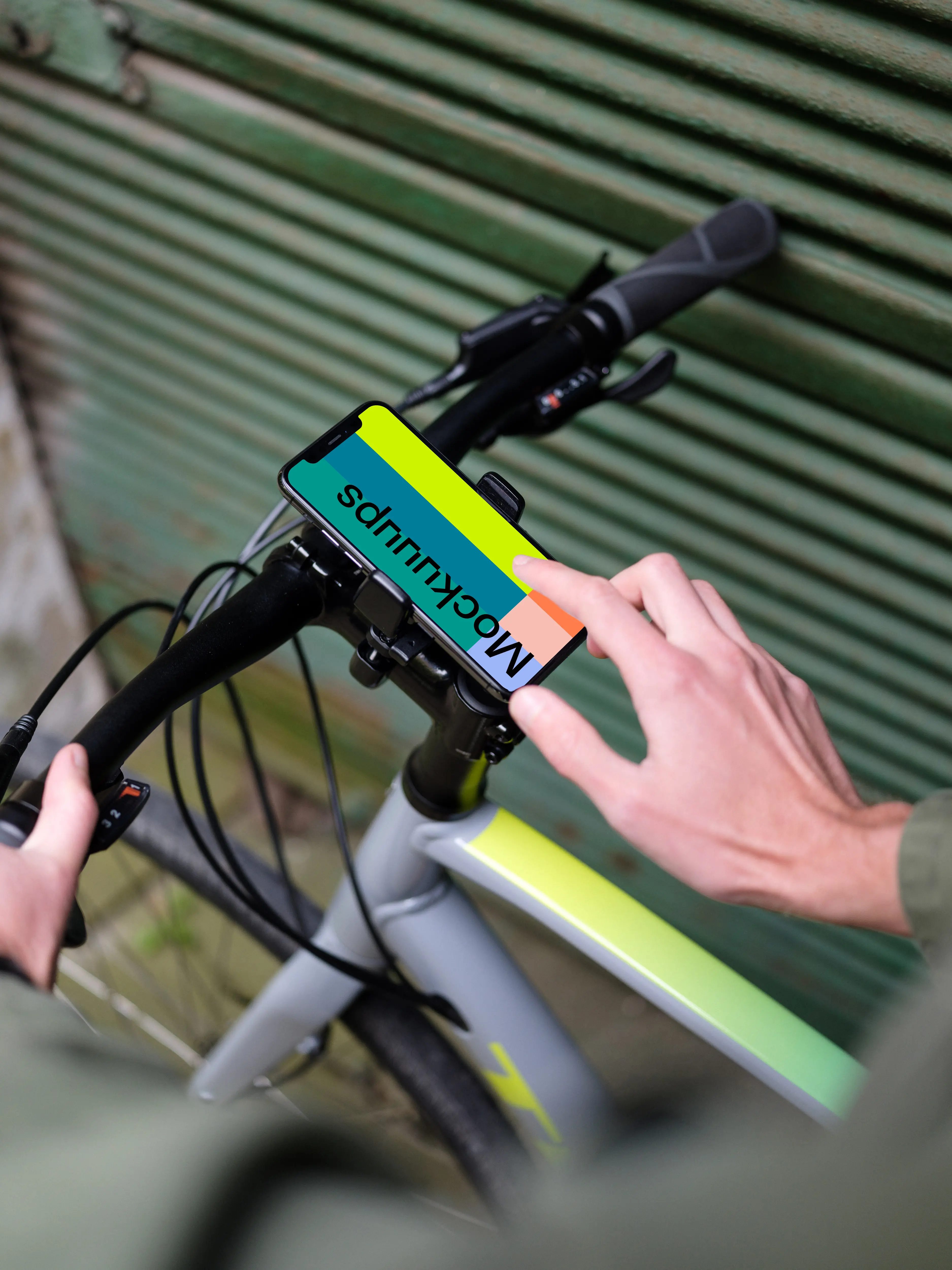 Man on bike next to a garage with iPhone 11 Pro mockup in bike mount