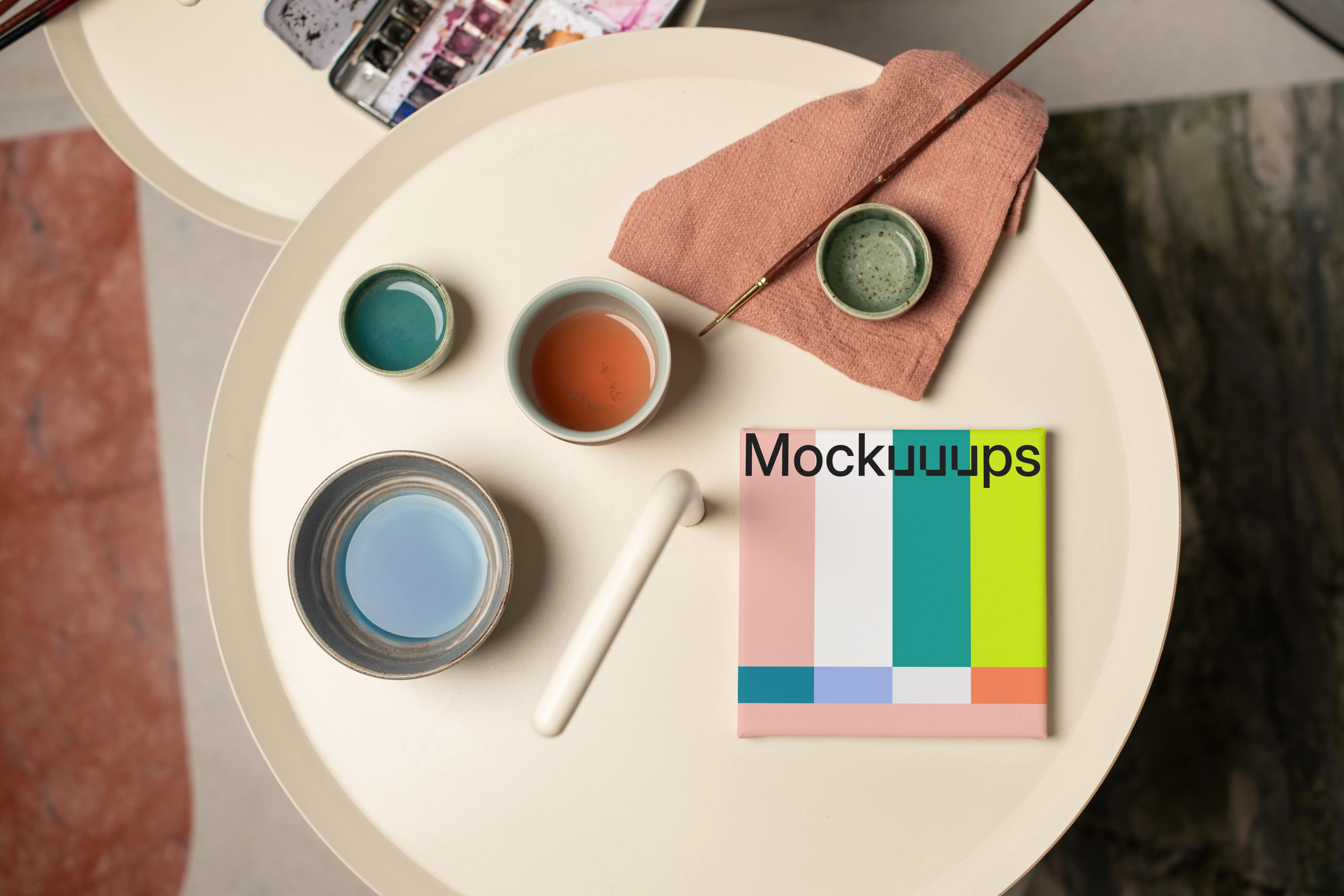 Mockup of a square poster with art supplies on a round table