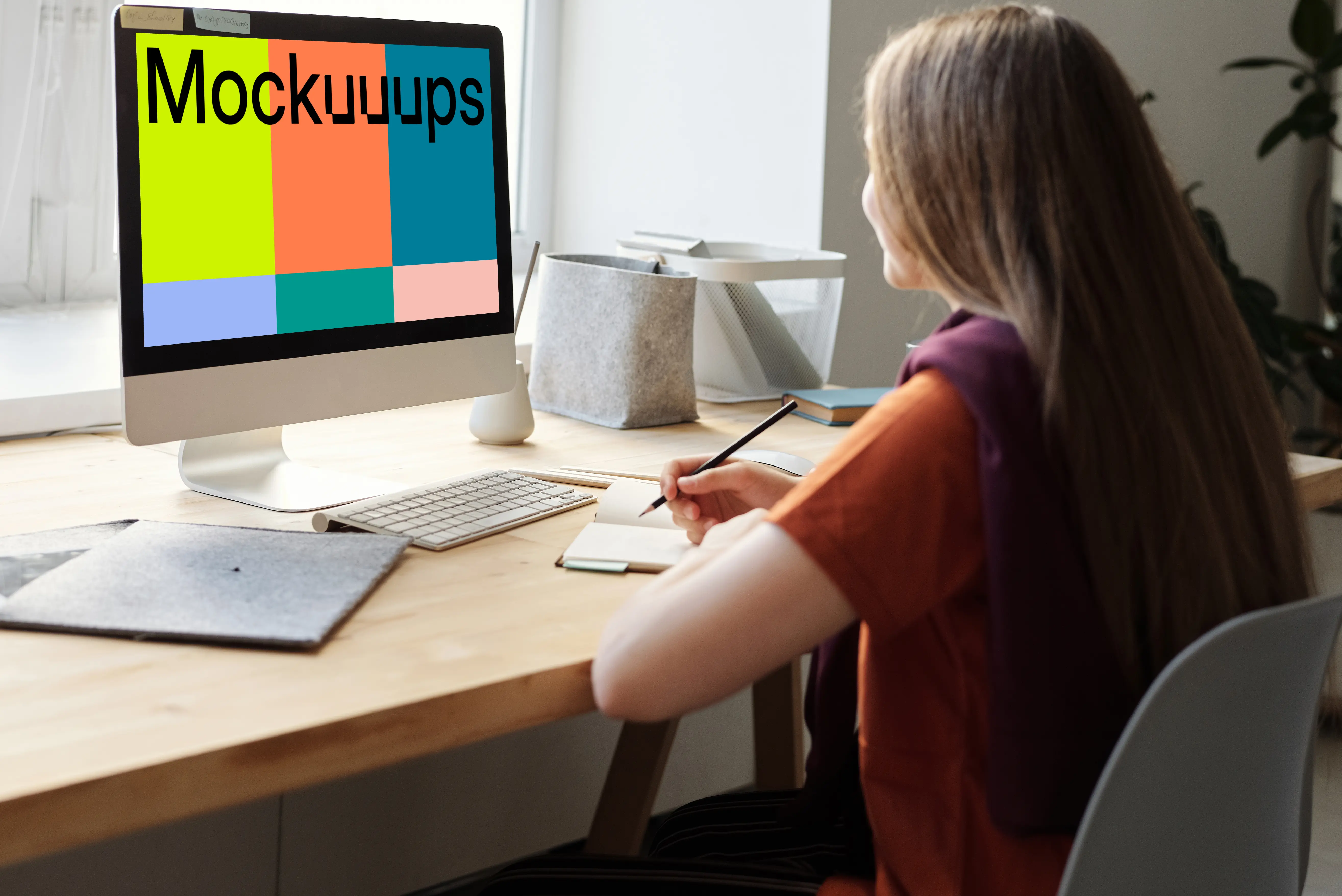 Mockup of a young girl using her iMac on a table