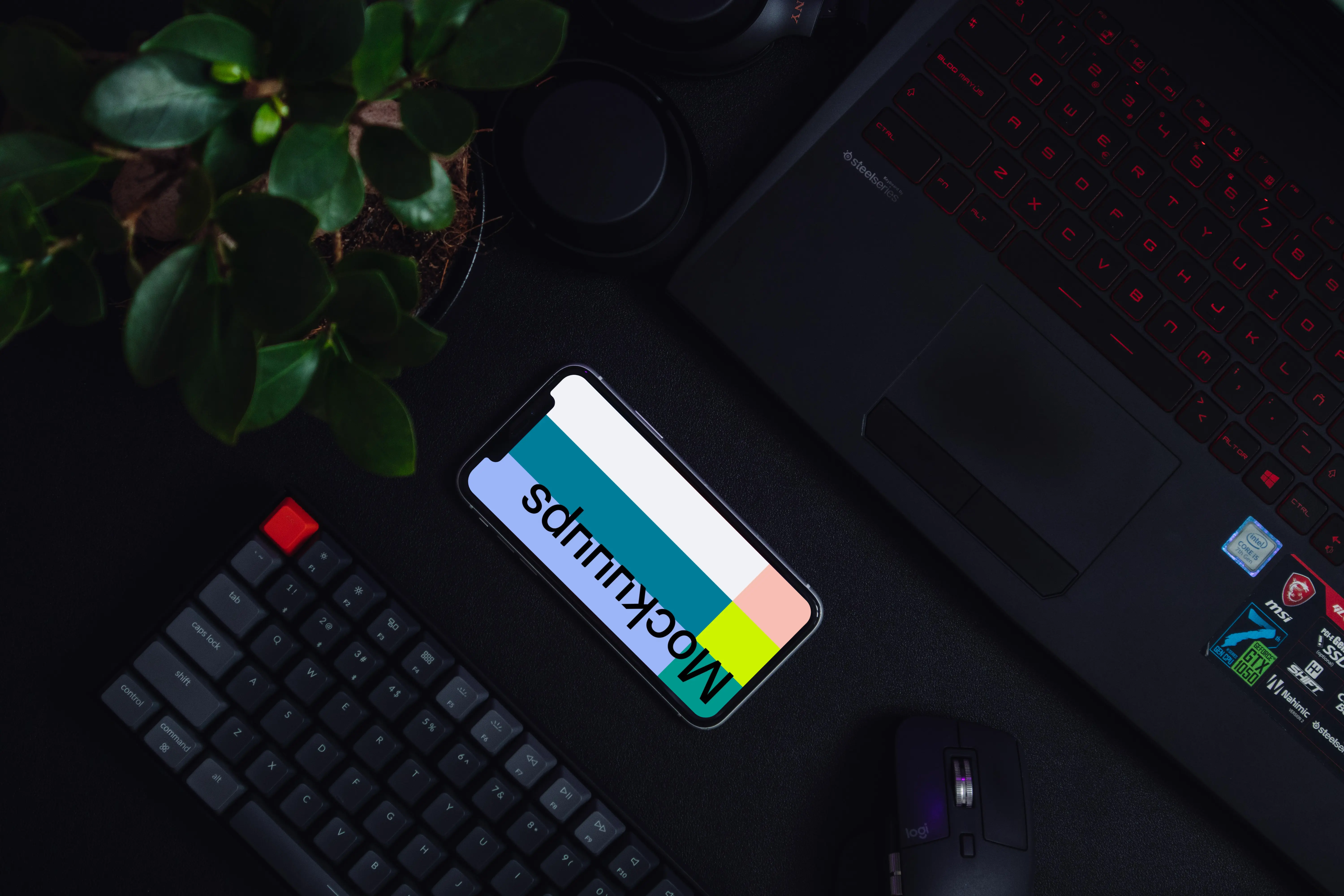 Night iPhone mockup on a table alongside a keyboard and flower pot