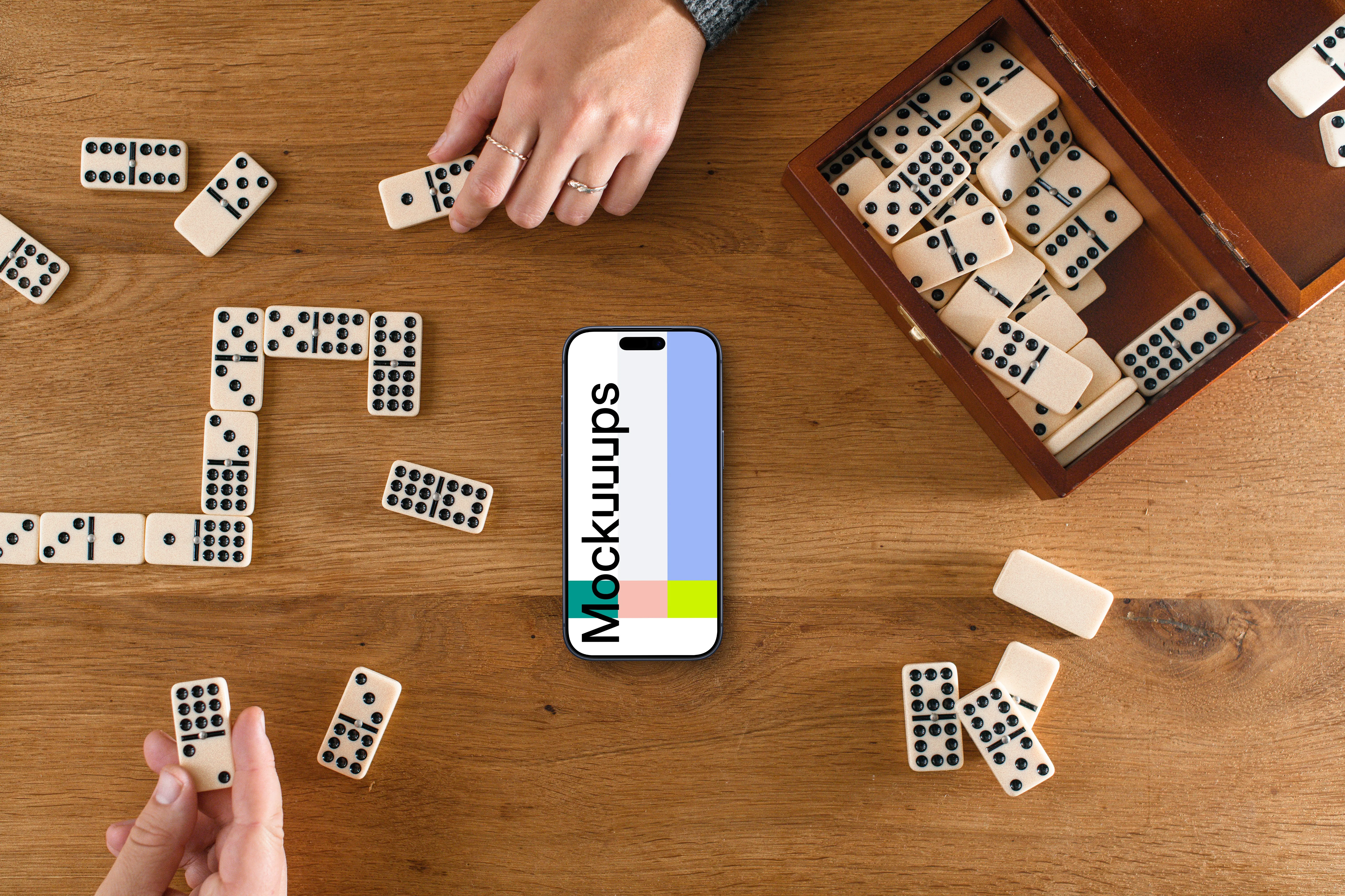 People playing dominoes next to the iPhone mockup