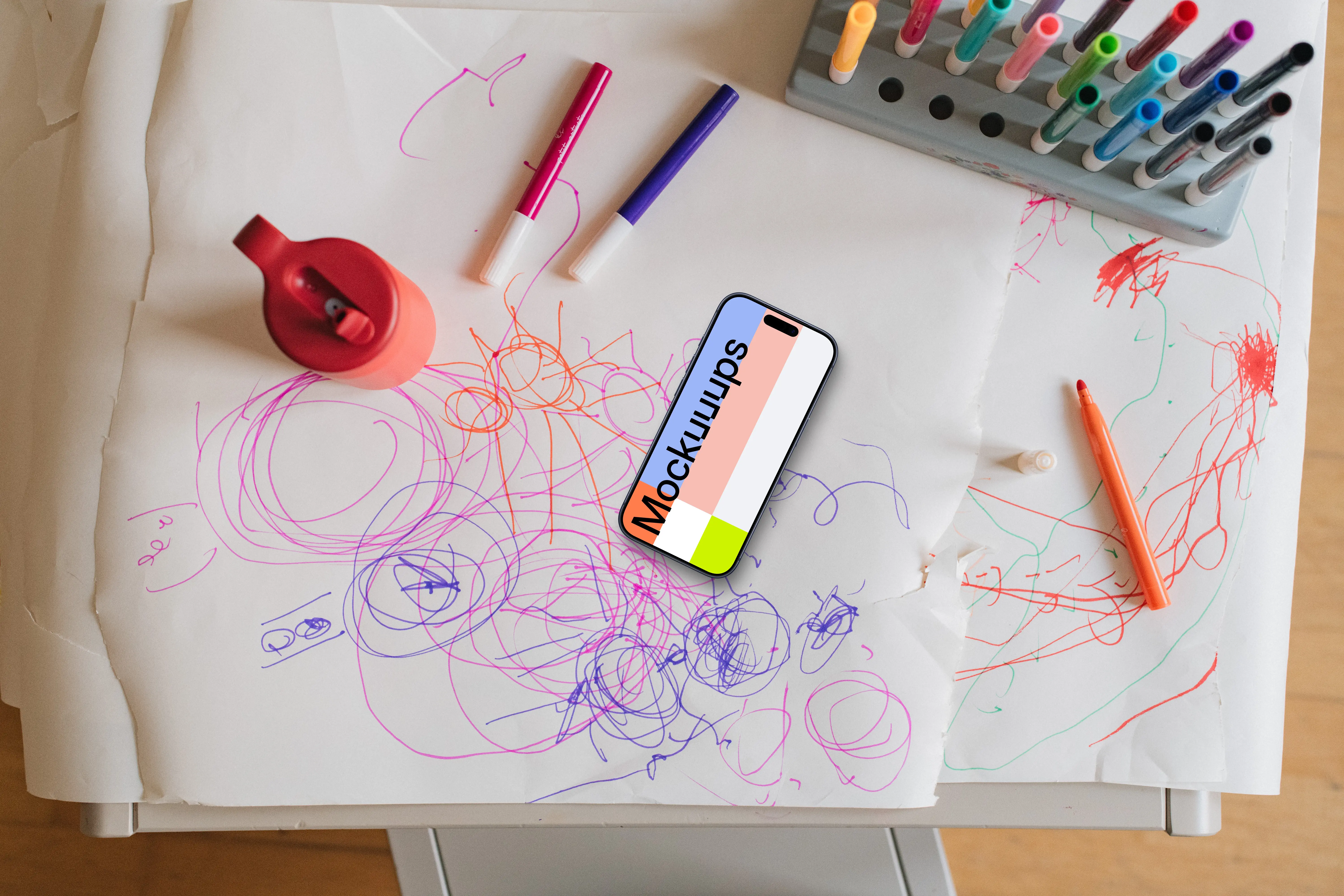 Smartphone mockup amidst colorful children's art