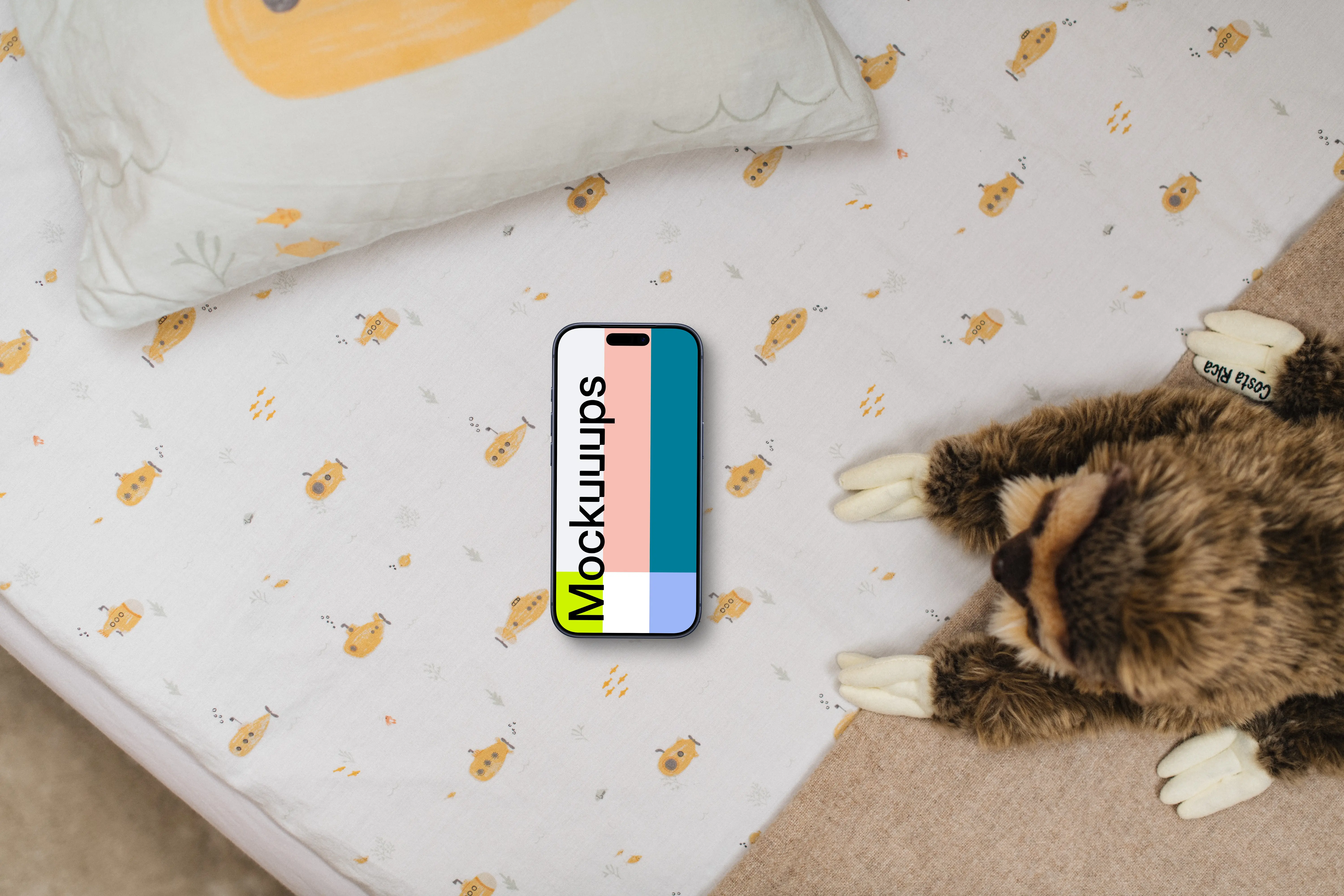 Smartphone mockup on children's bedding with plush toy