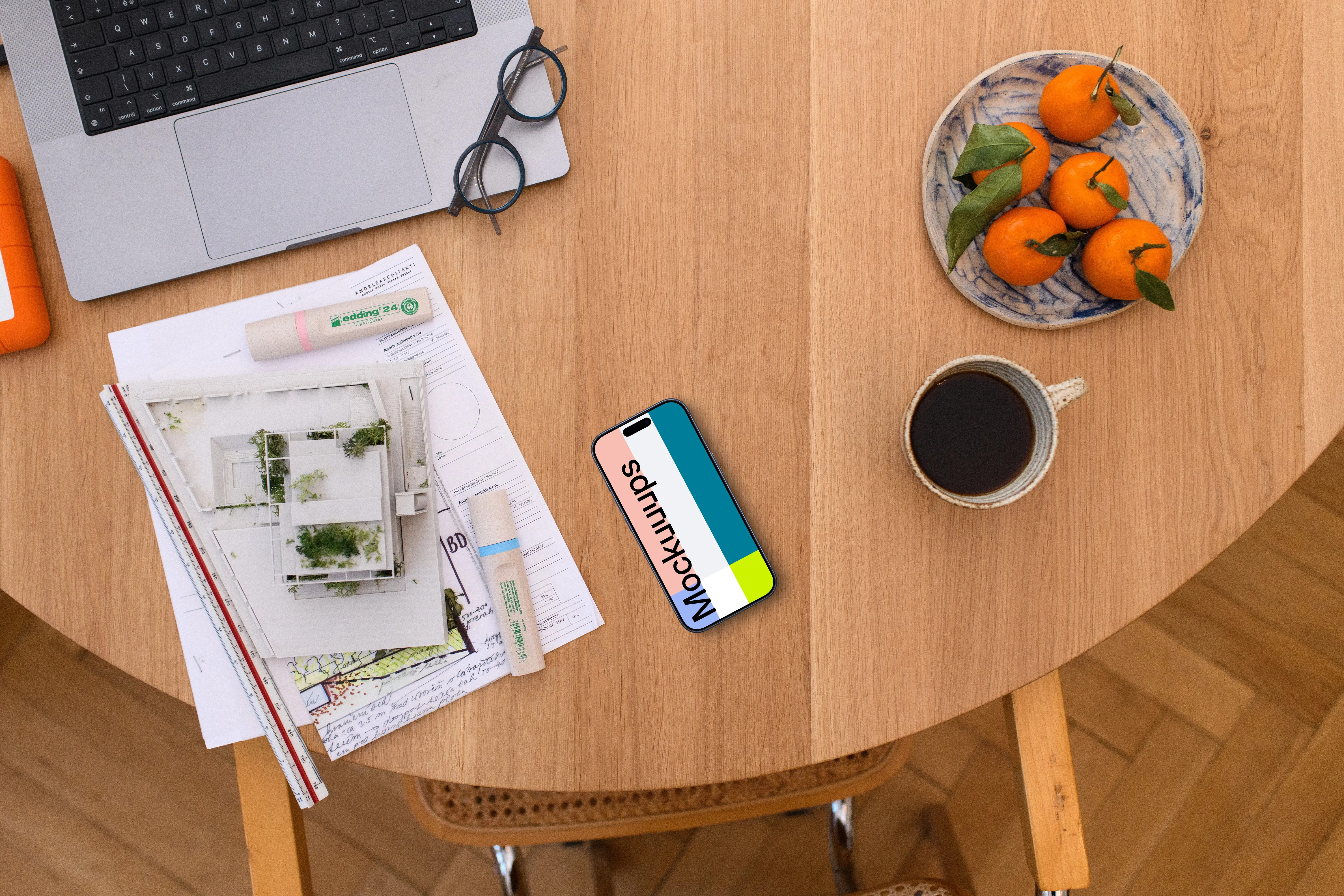 Smartphone mockup with architectural plans on a wooden table