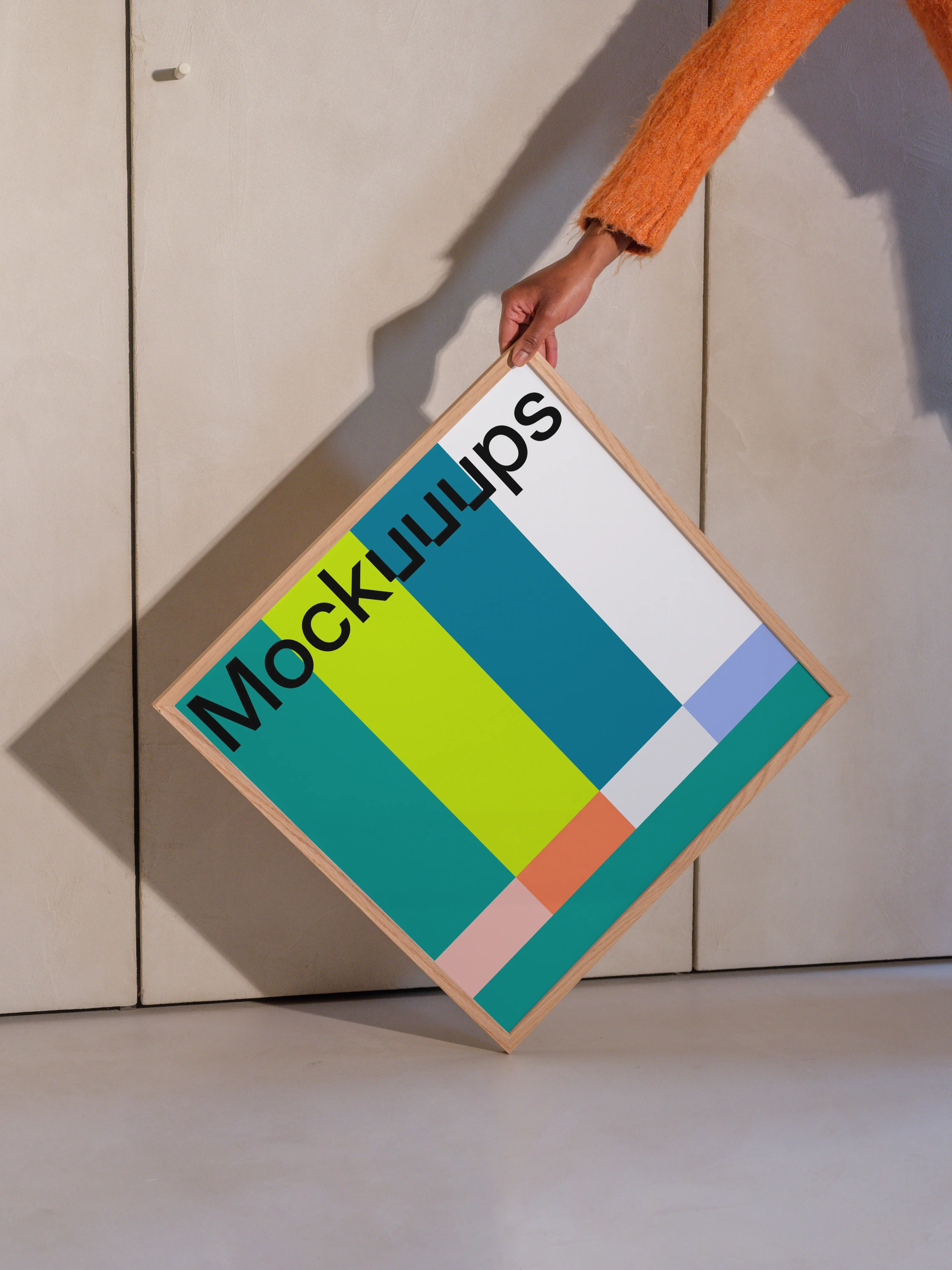 Square wooden frame mockup held against a textured wall