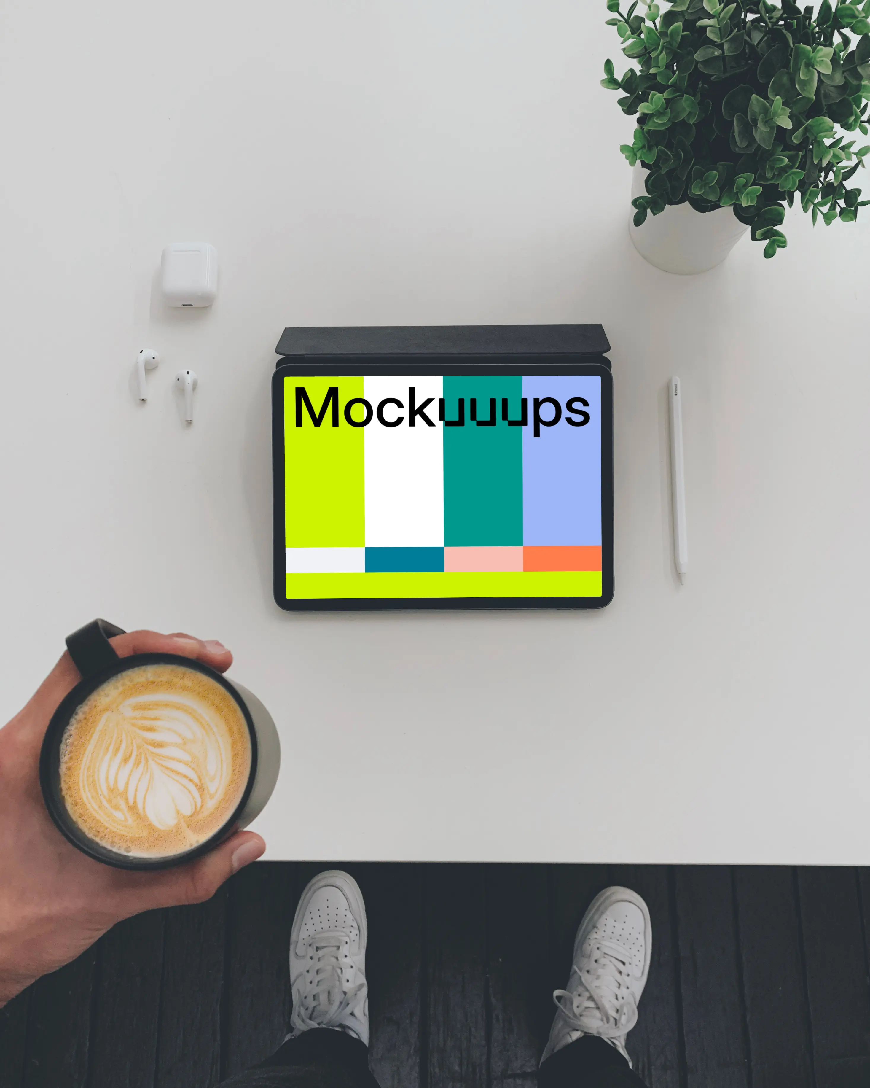 Tablet mockup on a white table with Airpods at the side