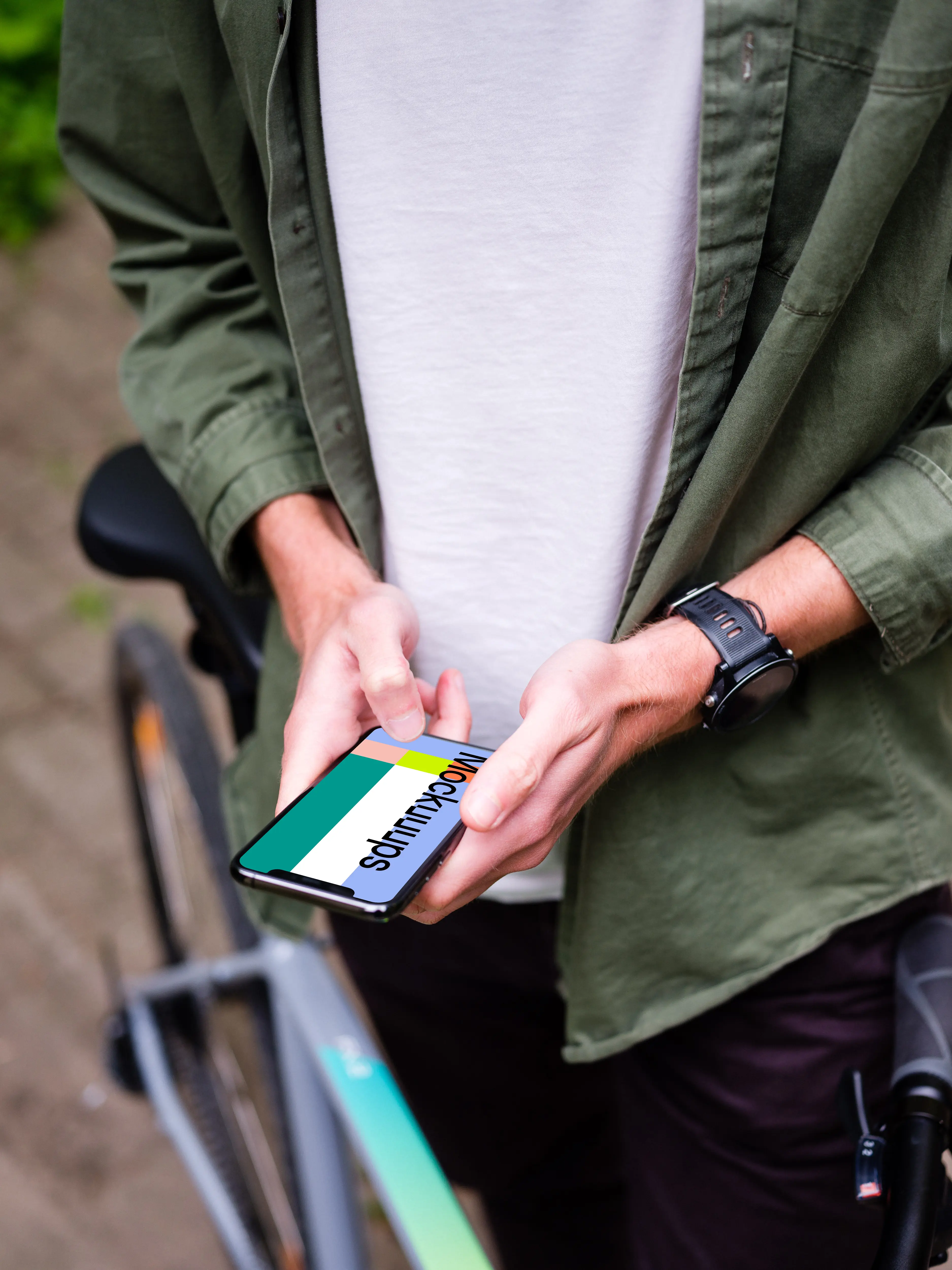 Typing on an iPhone 11 Pro mockup whilst stood with a bike