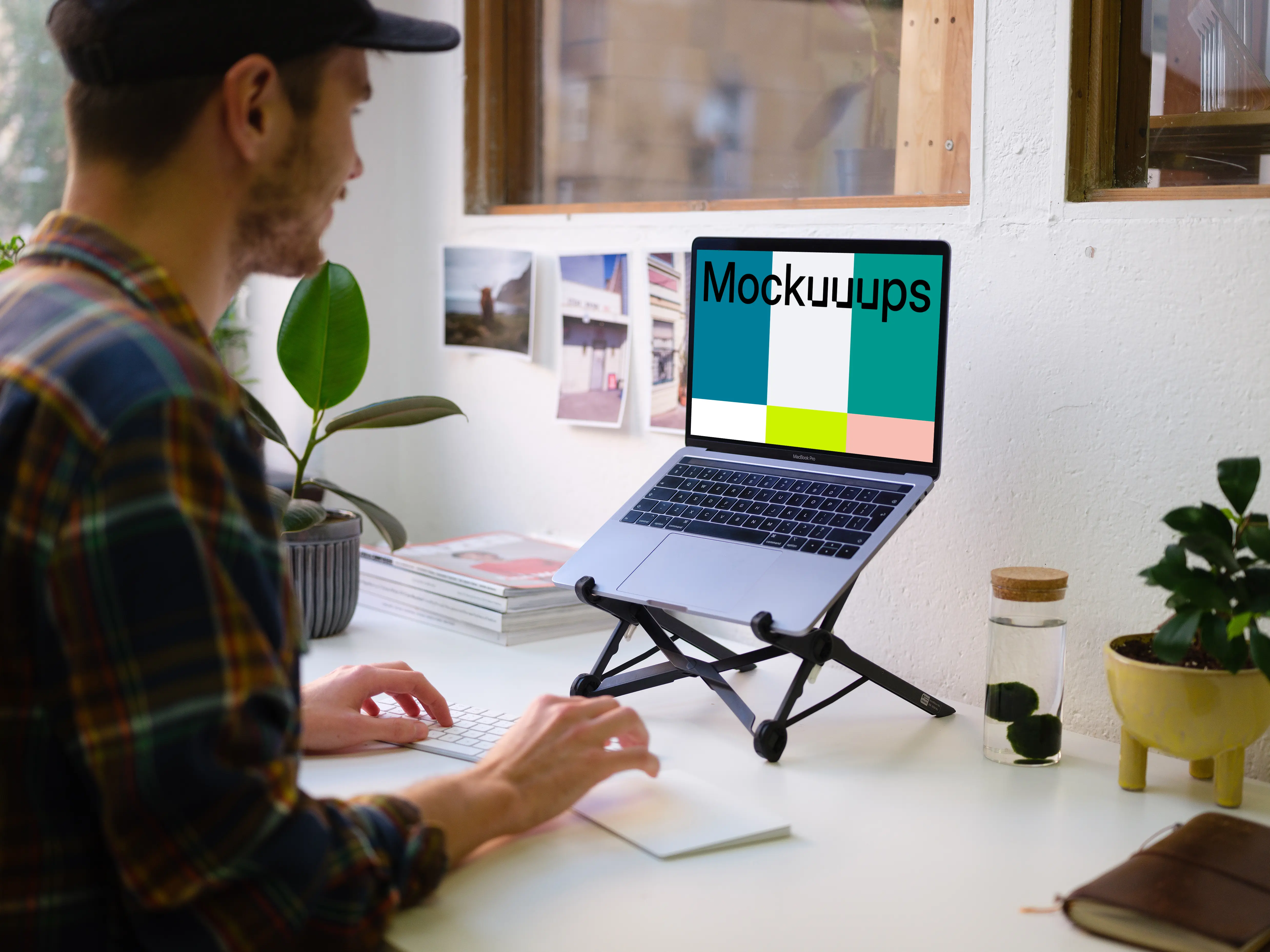 Young man working on the Macbook mockup in the bright office