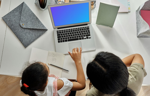 Adult teaching a young girl something on a MacBook Air mockup