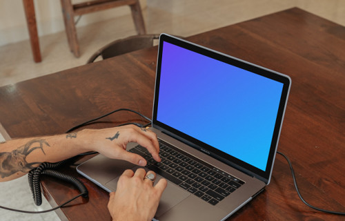 MacBook Pro mockup on a table with a mini-piano by the side