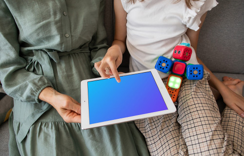 Adult showing a kid something on an iPad mockup