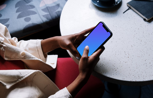 iPhone mockup in a dark-skinned females hand