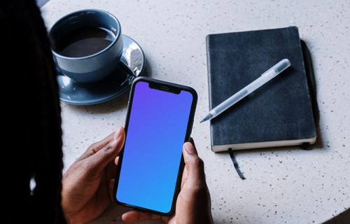 iPhone mockup in a ladies hand with a cup of coffee by the side