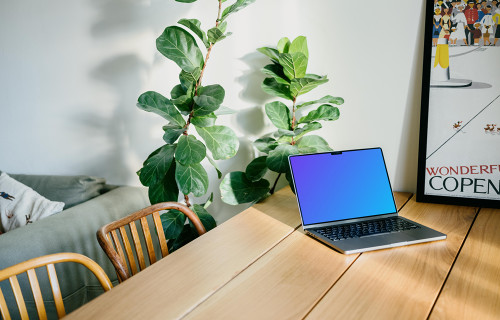 MacBook Pro mockup on a dining table beside a photo frame