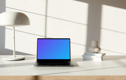 MacBook Pro mockup on a table beside a bright bulb