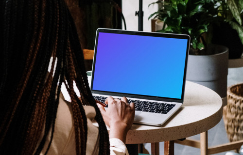 MacBook Pro mockup on white table with notebook by the side