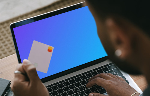 Mockup of man entering his card details into his MacBook 