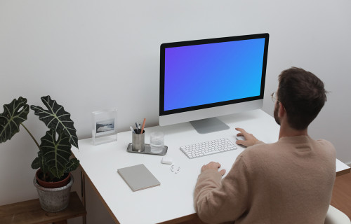 User using an iMac at his workstation