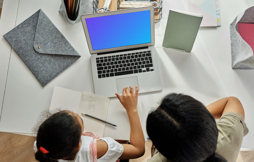 Adult teaching a young girl something on a MacBook Air mockup