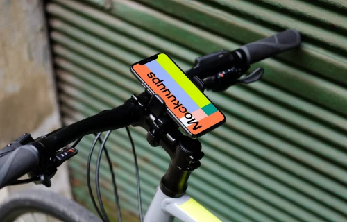 Bike leaned against a garage with iPhone 11 Pro mockup in bike mount