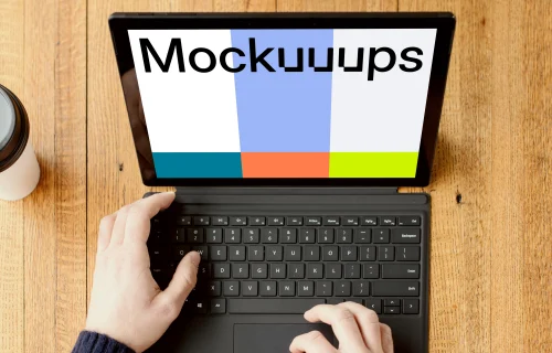 Black Microsoft Surface Laptop mockup on a wooden table.