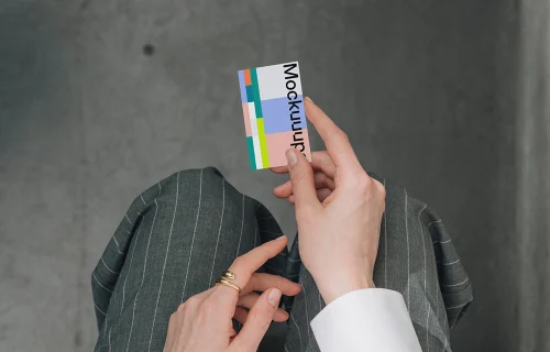 Business card mockup held over a pinstripe suit