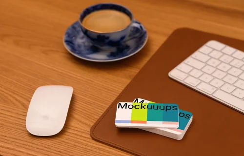 Business card mockup on a wooden desk with office items