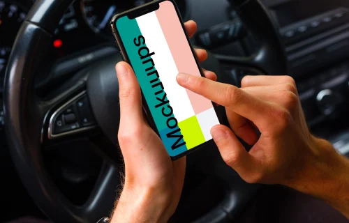 Driver tapping iPhone 11 mockup in front of steering wheel