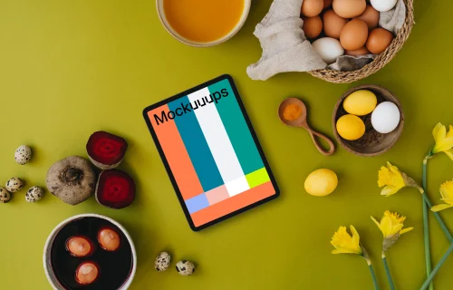 Easter eggs being colored next to a tablet mockup