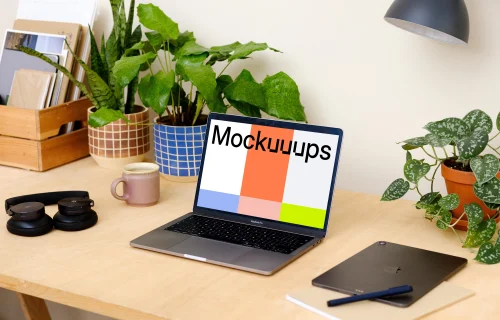 Grey MacBook Pro on a table with plants in the background