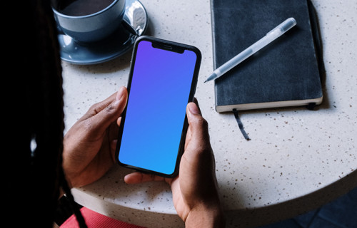 iPhone mockup in a ladies hand with a cup of coffee by the side