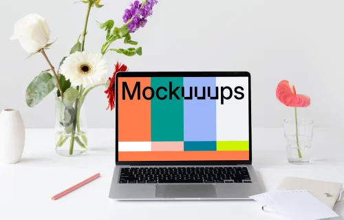 MacBook mockup on a table with flowers by the side