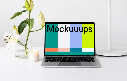 MacBook mockup on a white table with white table lamp at the side