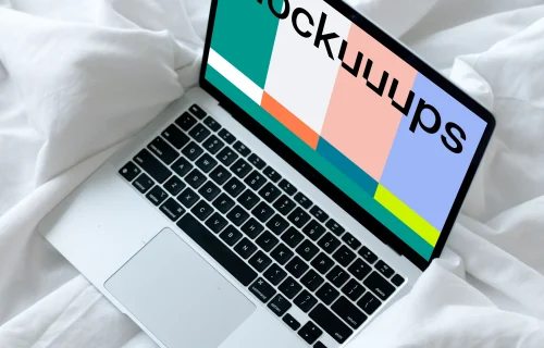MacBook mockup resting on a white bed