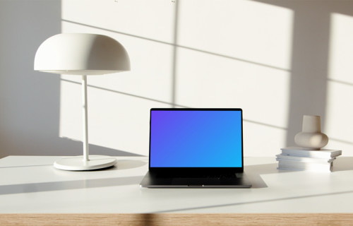 MacBook Pro mockup on a table beside a bright bulb