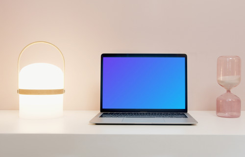 MacBook Pro mockup on a table beside an hourglass