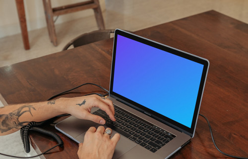 MacBook Pro mockup on a table with a mini-piano by the side