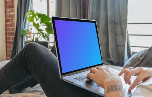 MacBook Pro mockup on man's legs in a bedroom
