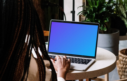 MacBook Pro mockup on white table with notebook by the side