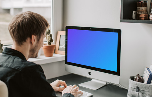 Man typing into his iMac mockup