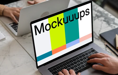 Notebook mockup on a table opposite another MacBook Pro