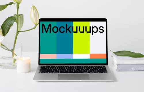 Simple MacBook mockup on a white workstation table with a plant at the side