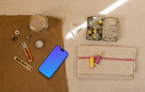 Smartphone mockup next to sewing accessories