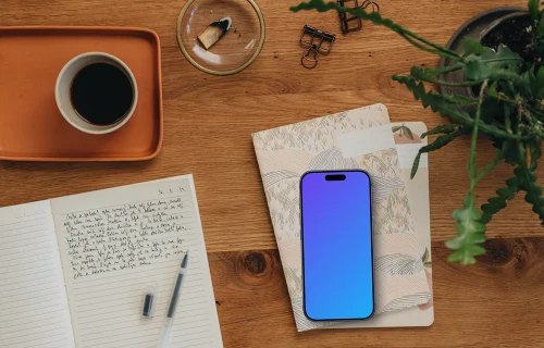Styled journaling scene with an iPhone mockup