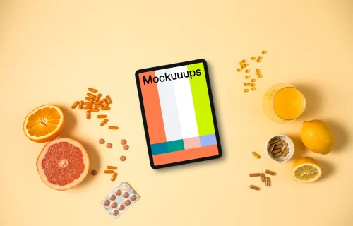 Tablet surrounded by pills and citrus fruits