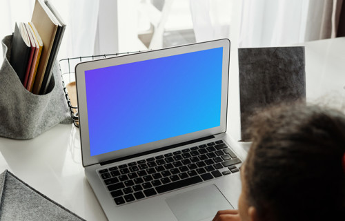 Young girl working on her MacBook Air mockup