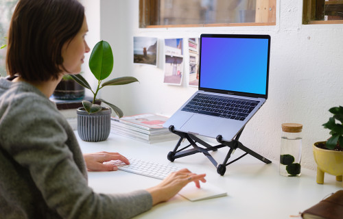 Young woman working on the Macbook Pro mockup in the bright office