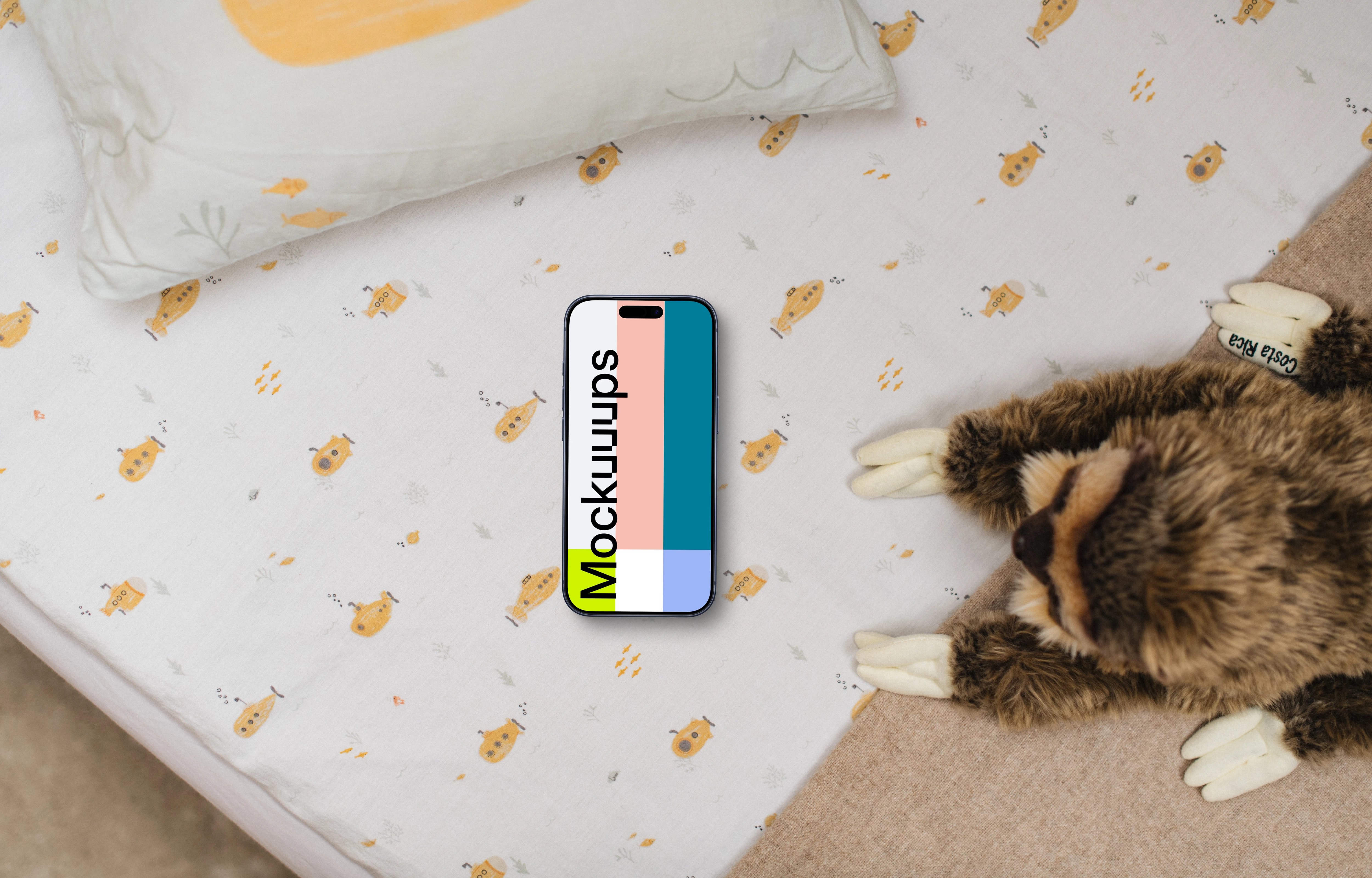 Smartphone mockup on children's bedding with plush toy